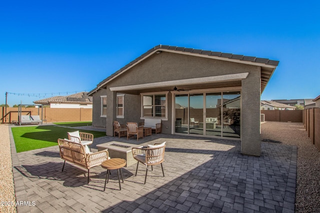 view of patio with ceiling fan and an outdoor living space with a fire pit