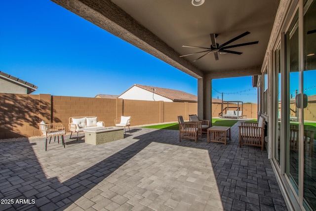 view of patio featuring ceiling fan and an outdoor living space with a fire pit