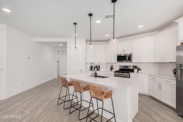 kitchen with stainless steel appliances, white cabinetry, and sink