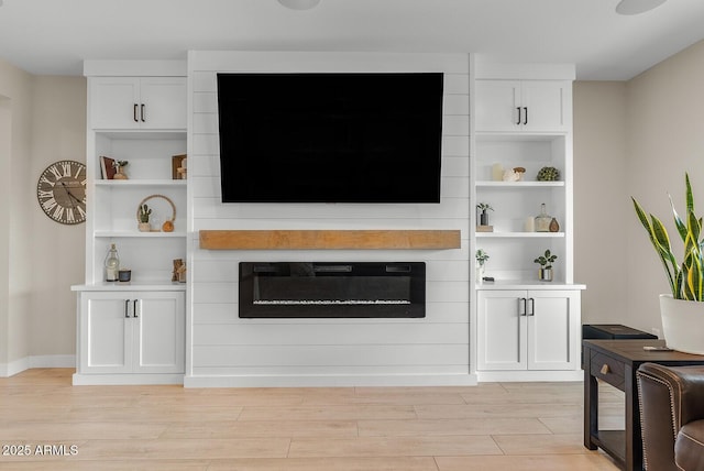 living area with light wood finished floors and a large fireplace