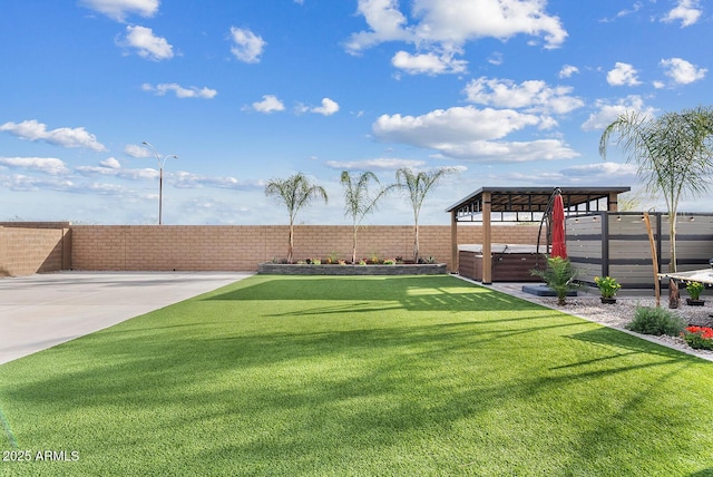 view of yard featuring a fenced backyard and a hot tub