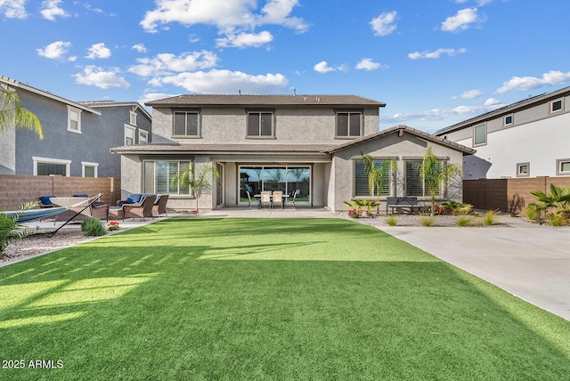 rear view of property with a patio, a yard, a fenced backyard, and stucco siding