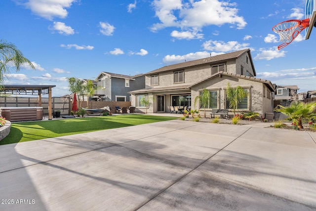 back of house featuring stucco siding, a patio, a lawn, and fence