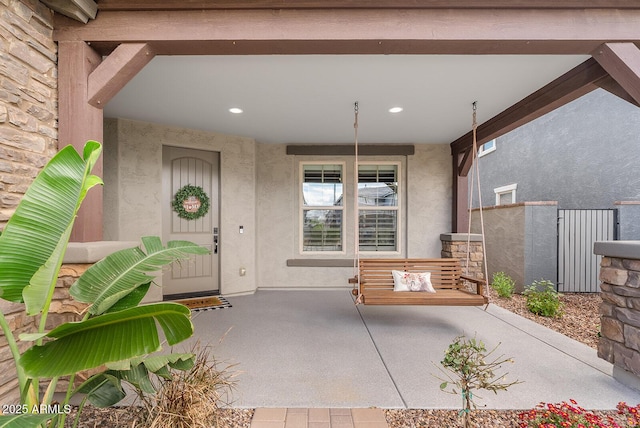 doorway to property featuring stucco siding and a porch