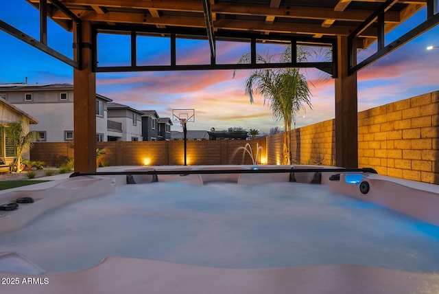 view of swimming pool with a fenced backyard and a hot tub