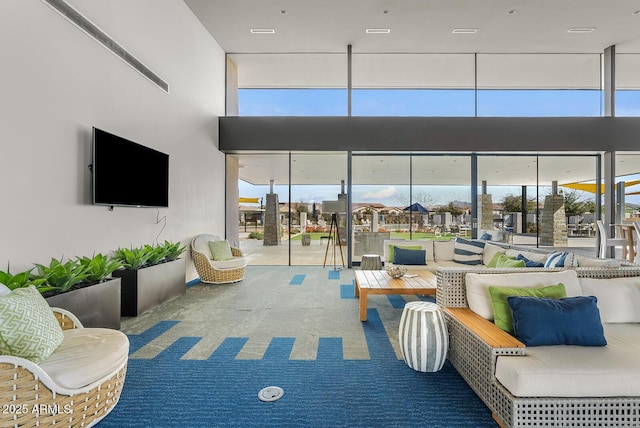 carpeted living room with a towering ceiling