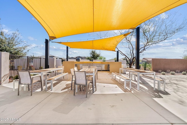 view of patio / terrace featuring outdoor dining space, an outdoor kitchen, and fence