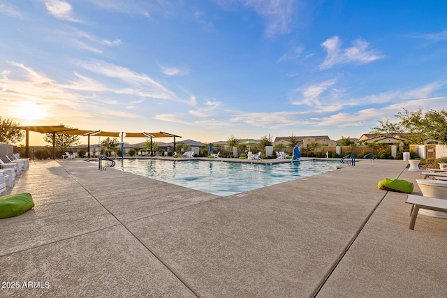 pool with a patio area and fence