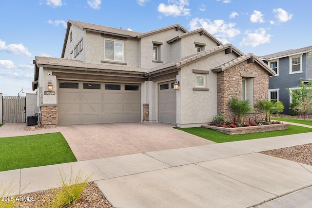 view of front of house featuring fence, stucco siding, decorative driveway, stone siding, and an attached garage