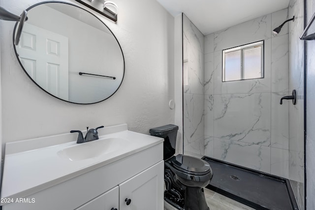 bathroom featuring a tile shower, vanity, and toilet