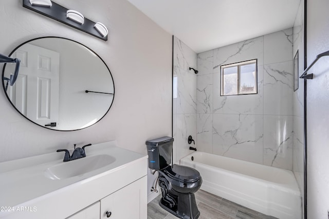 full bathroom featuring wood-type flooring, tiled shower / bath, vanity, and toilet