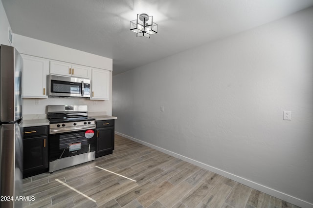 kitchen with white cabinets, stainless steel appliances, and light wood-type flooring