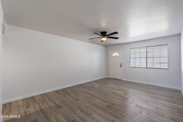 spare room with wood-type flooring, ceiling fan, and a textured ceiling