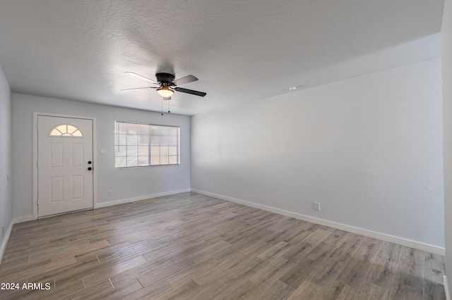 entryway featuring a textured ceiling, light hardwood / wood-style floors, and ceiling fan