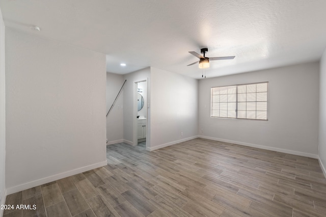 empty room featuring a textured ceiling, wood-type flooring, and ceiling fan