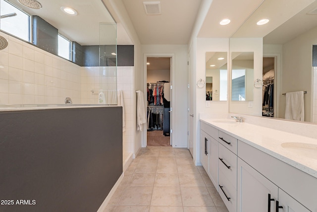 bathroom with tile patterned floors, a shower, and vanity