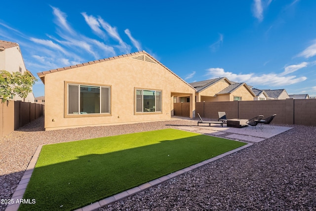 back of property with a yard and a patio