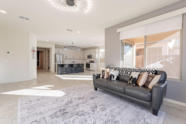 tiled living room featuring a notable chandelier