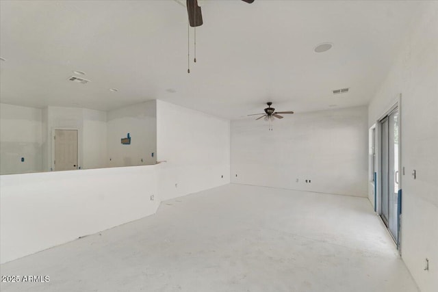 unfurnished room with visible vents, concrete floors, and ceiling fan