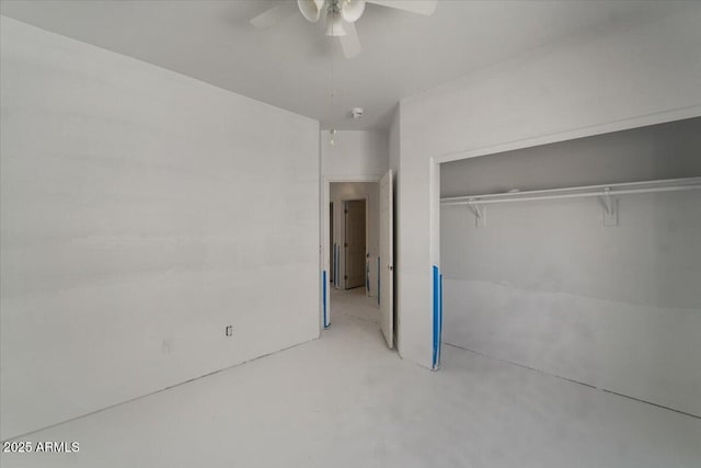 unfurnished bedroom featuring a ceiling fan, concrete flooring, and a closet