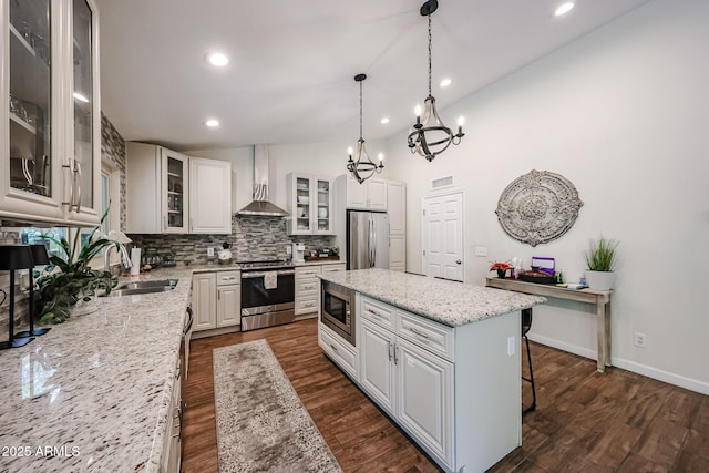 9085 E Windrose Dr, Scottsdale, AZ 85260 - kitchen with stainless steel appliances, wall chimney range hood, a chandelier, backsplash, and a kitchen island
