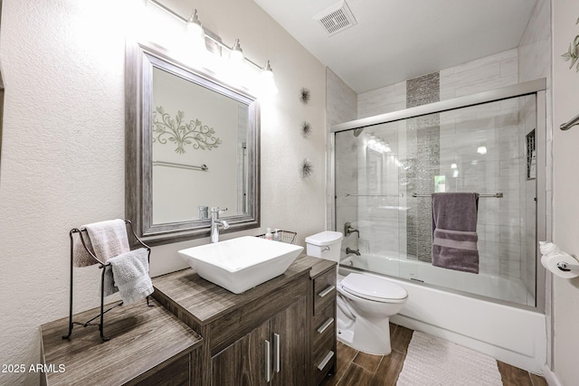 9085 E Windrose Dr, Scottsdale, AZ 85260 - full bathroom with vanity, enclosed tub / shower combo, wood finished floors, and a textured wall