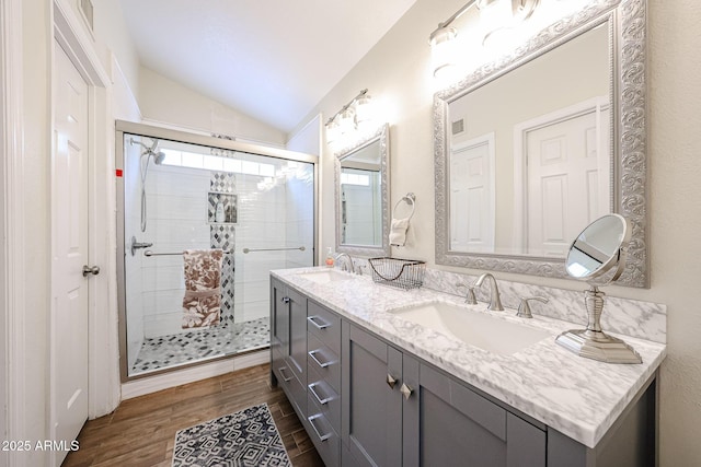 9085 E Windrose Dr, Scottsdale, AZ 85260 - bathroom featuring lofted ceiling, double vanity, a stall shower, plenty of natural light, and wood finished floors