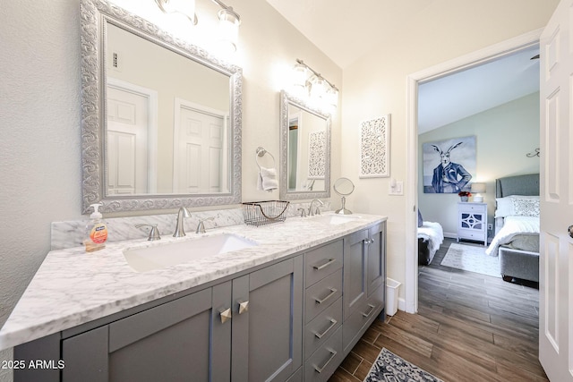 9085 E Windrose Dr, Scottsdale, AZ 85260 - bathroom featuring ensuite bath, vaulted ceiling, double vanity, and wood finished floors
