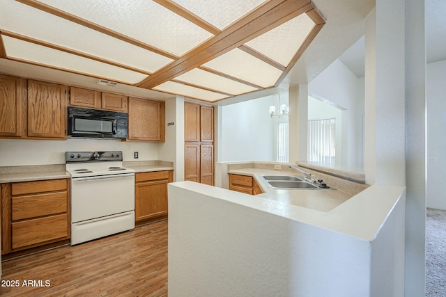 kitchen with white range with electric stovetop, light wood finished floors, visible vents, a sink, and black microwave