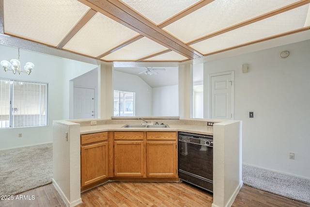 kitchen featuring lofted ceiling, open floor plan, dishwasher, and a sink