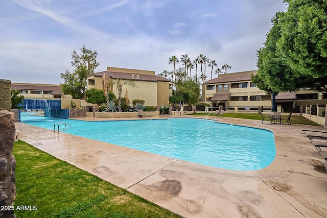 pool with a patio area and fence