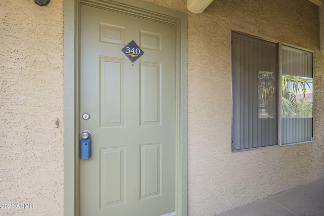 view of exterior entry featuring stucco siding