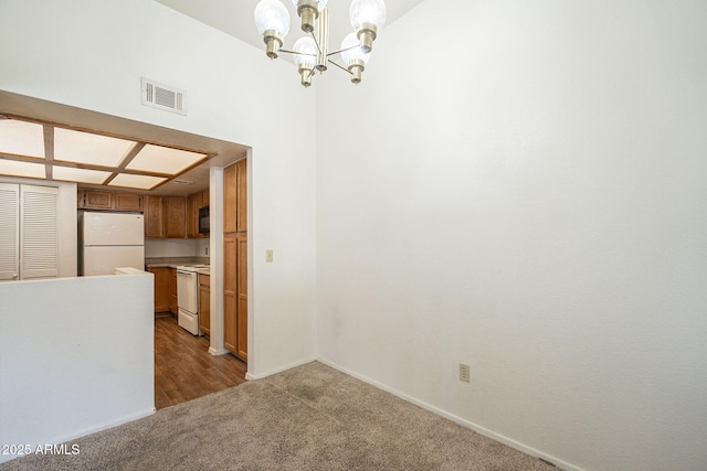 unfurnished dining area with a chandelier, carpet, visible vents, and baseboards