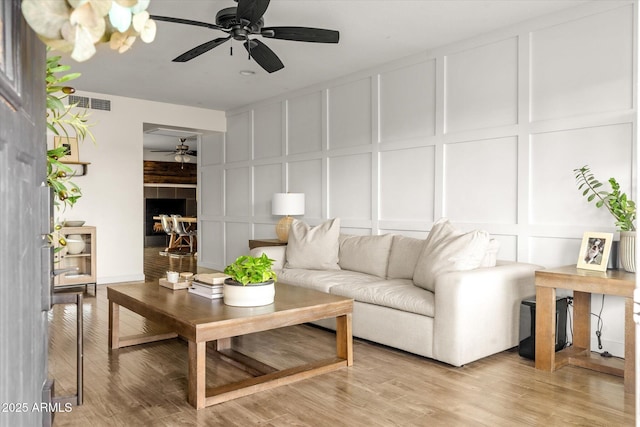 2418 E Hermosa Dr, Tempe, AZ 85282 - living area featuring a decorative wall, a ceiling fan, and light wood finished floors