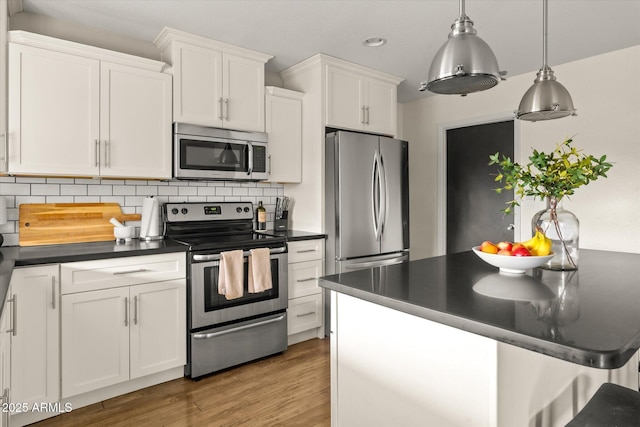 2418 E Hermosa Dr, Tempe, AZ 85282 - kitchen with stainless steel appliances, dark countertops, white cabinets, tasteful backsplash, and recessed lighting