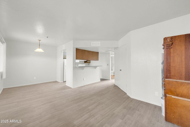 unfurnished living room featuring light wood-style flooring, baseboards, and visible vents