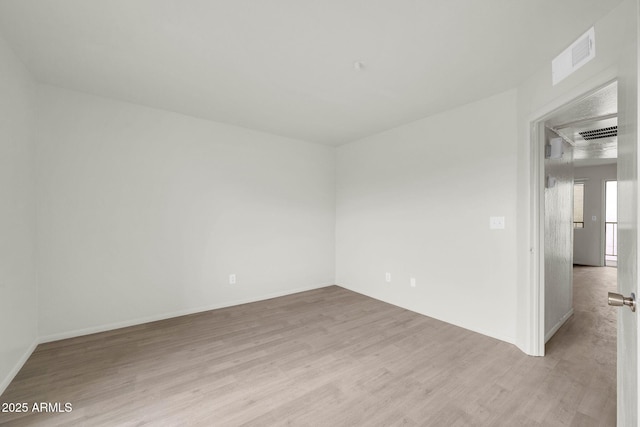 spare room featuring visible vents and light wood finished floors