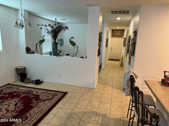 hall with an inviting chandelier and light tile floors