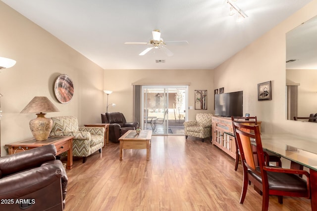 living room with ceiling fan, light wood-type flooring, and track lighting