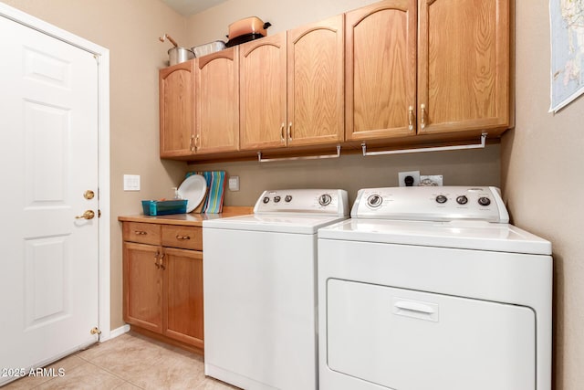 clothes washing area with light tile patterned floors, cabinets, and independent washer and dryer