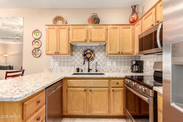 kitchen with kitchen peninsula, ceiling fan, sink, and appliances with stainless steel finishes