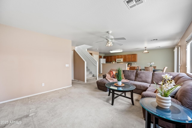 2327 E Meadow Creek Way, San Tan Valley, AZ 85140 - living area with light colored carpet, stairs, a ceiling fan, and baseboards