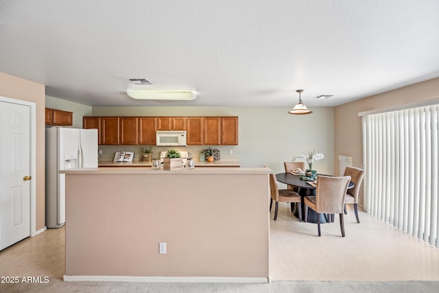 2327 E Meadow Creek Way, San Tan Valley, AZ 85140 - kitchen featuring white appliances, brown cabinets, light countertops, pendant lighting, and a center island