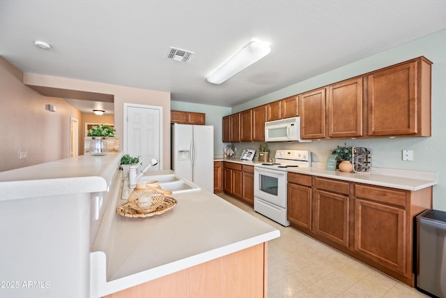2327 E Meadow Creek Way, San Tan Valley, AZ 85140 - kitchen with white appliances, a sink, and brown cabinetry