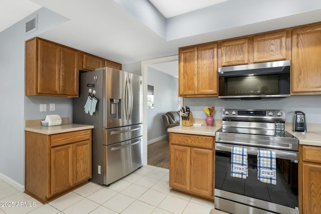 kitchen with light tile patterned flooring and appliances with stainless steel finishes