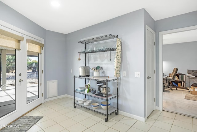 entryway featuring light tile patterned flooring and french doors