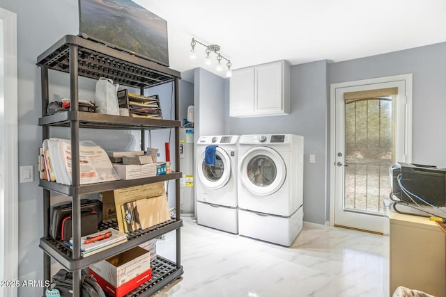 laundry area with water heater, cabinets, and washing machine and dryer