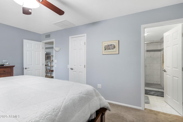 bedroom featuring ceiling fan, light colored carpet, and ensuite bath