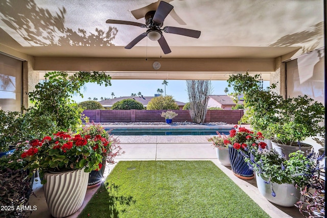 view of pool with ceiling fan and a lawn