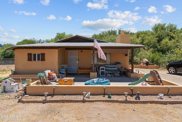 rear view of property featuring a patio and outdoor lounge area